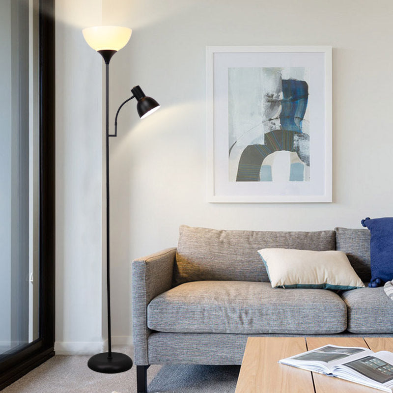 Schwarze Stehlampe mit Leselicht neben grauem Sofa und abstraktem Wandbild