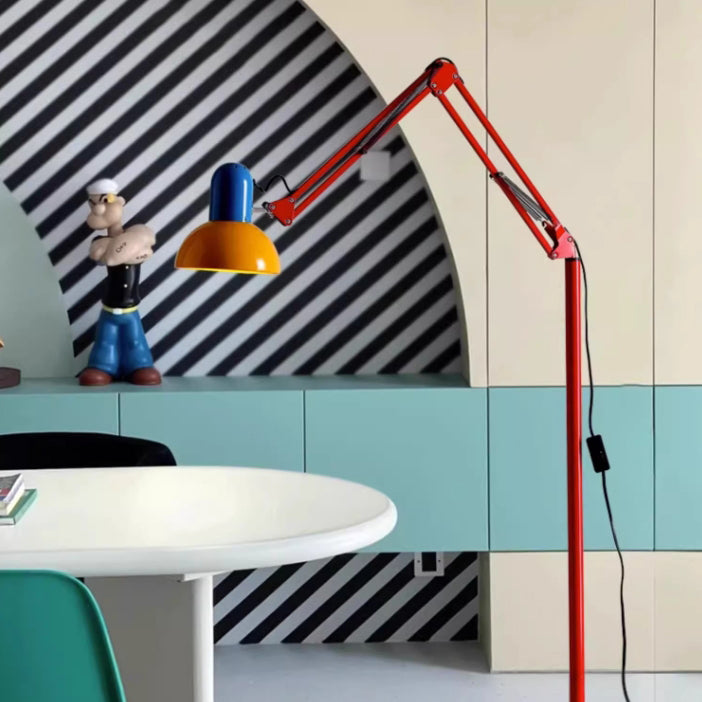 Farbige Stehlampe mit rotem Rahmen und gelber Leuchte neben grafischer Wand