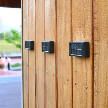 Zwei kompakte Solarlampen an Holzwand bei Tageslicht montiert