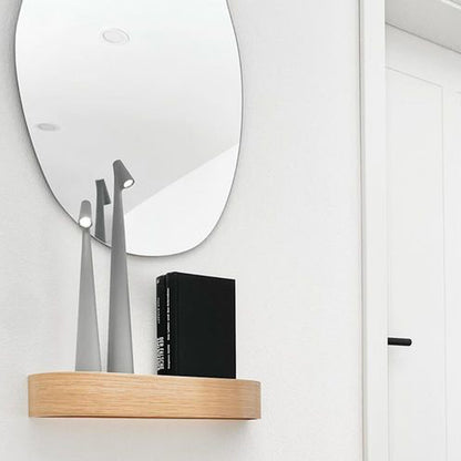 Schmale Lampe mit Holzoptik vor Spiegel auf hellem Sideboard