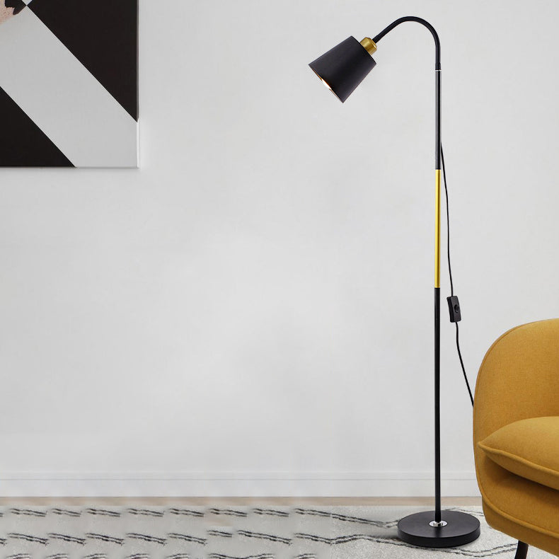 Schwarze Stehlampe mit Holzgriff neben gelbem Sessel auf hellem Teppich