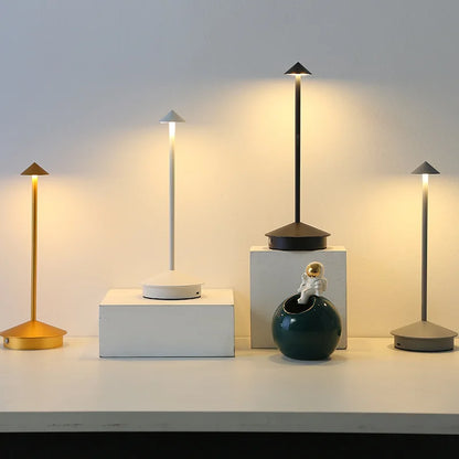 Fünf LED-Tischlampen in Schwarz, Gold und Weiß auf modernem Sideboard