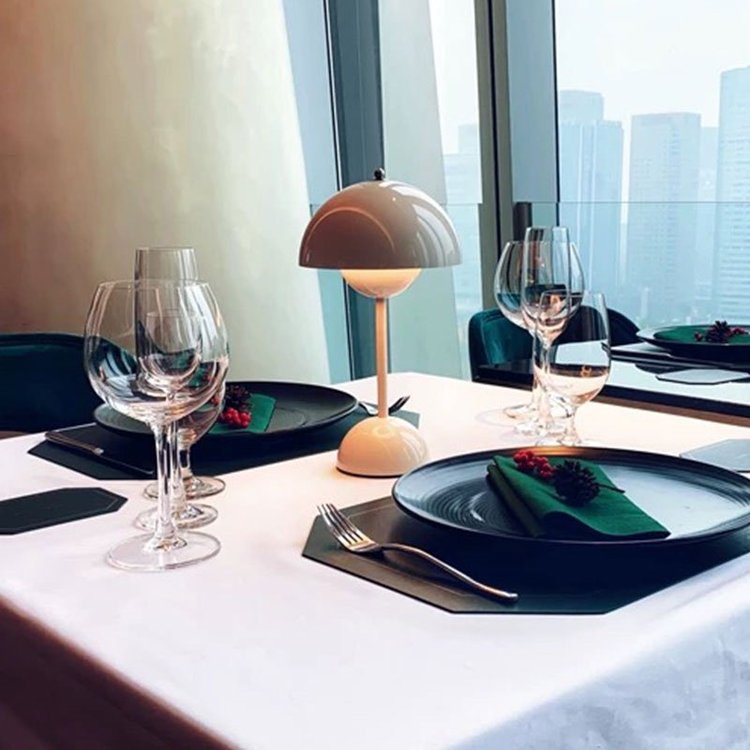 Dunkelorange Lampe auf gedecktem Esstisch mit Fensterblick