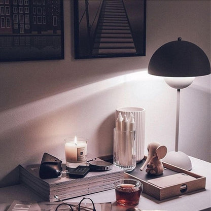 Schwarze Tischlampe leuchtet über Kerzen auf Holztablett